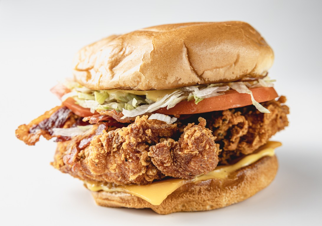 Bacon club chicken sandwich with beef bacon, cheddar, lettuce and tomato on a brioche bun
