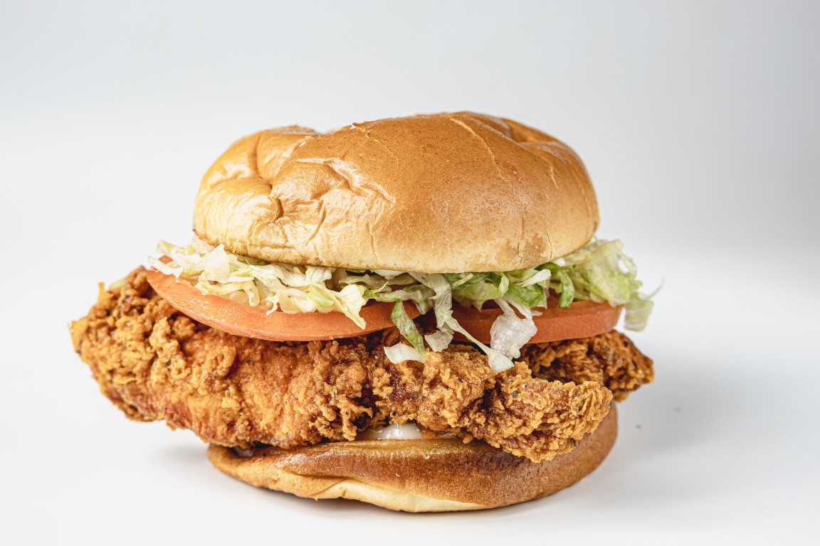 Classic chicken sandwich with lettuce, tomato and mayo on a brioche bun